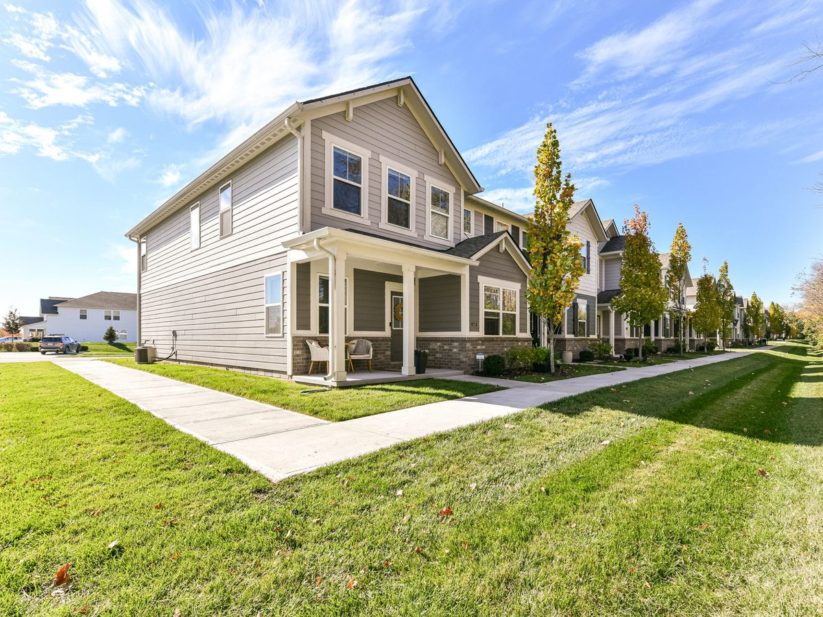 Craftsman-style homes along a neighborhood sidewalk in fall